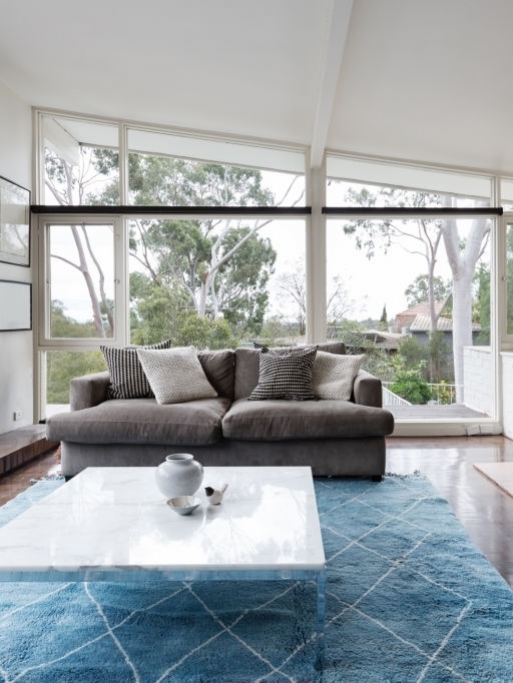 Mid century modern living room with huge windows to view the Australian treetops