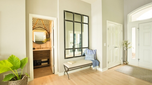 A contemporary home entry hallway foyer with bathroom and interior front door.