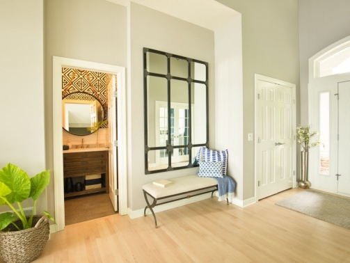 A contemporary home entry hallway foyer with bathroom and interior front door.